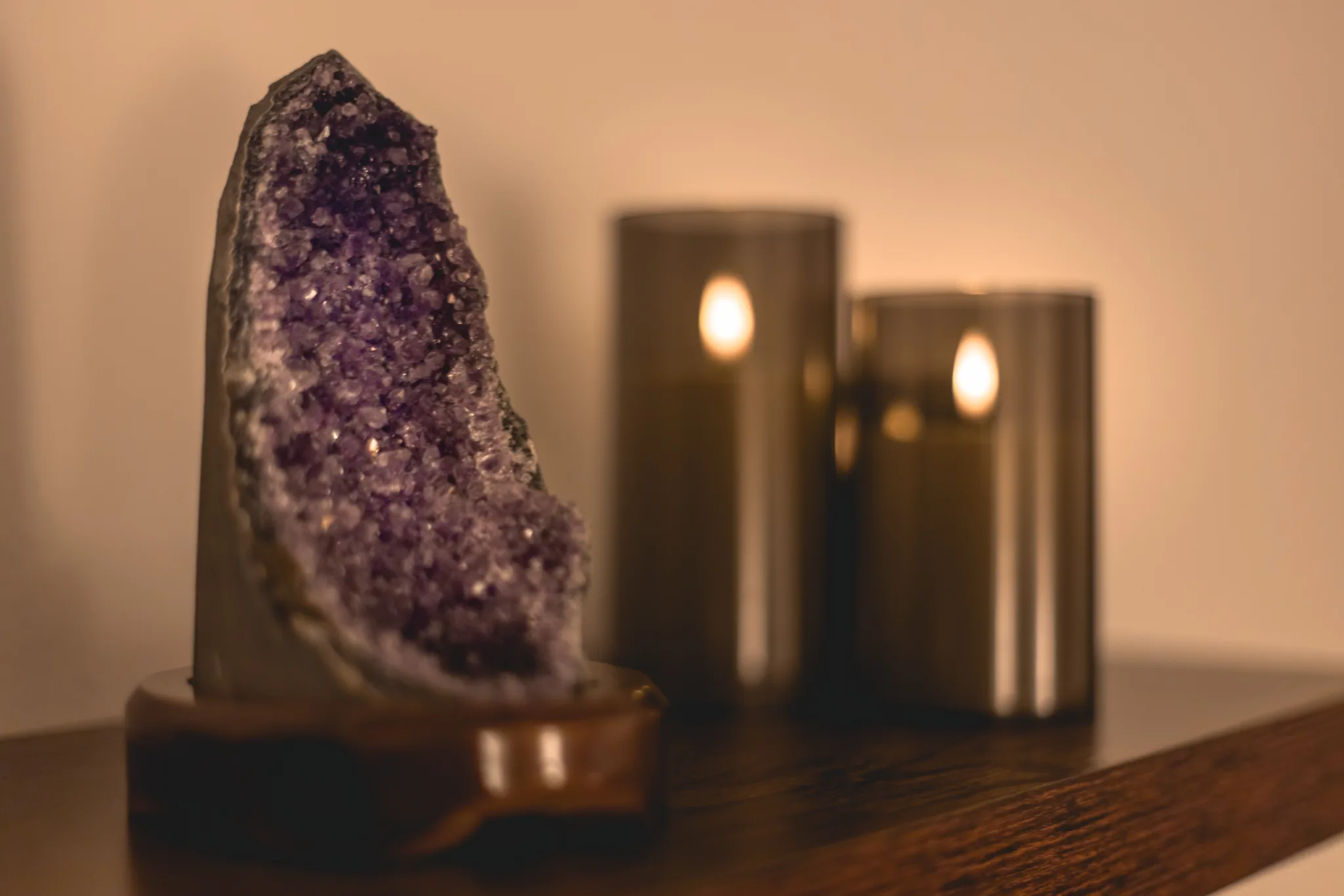 An amethyst crystal and candles on a shelf in the treatment space.
