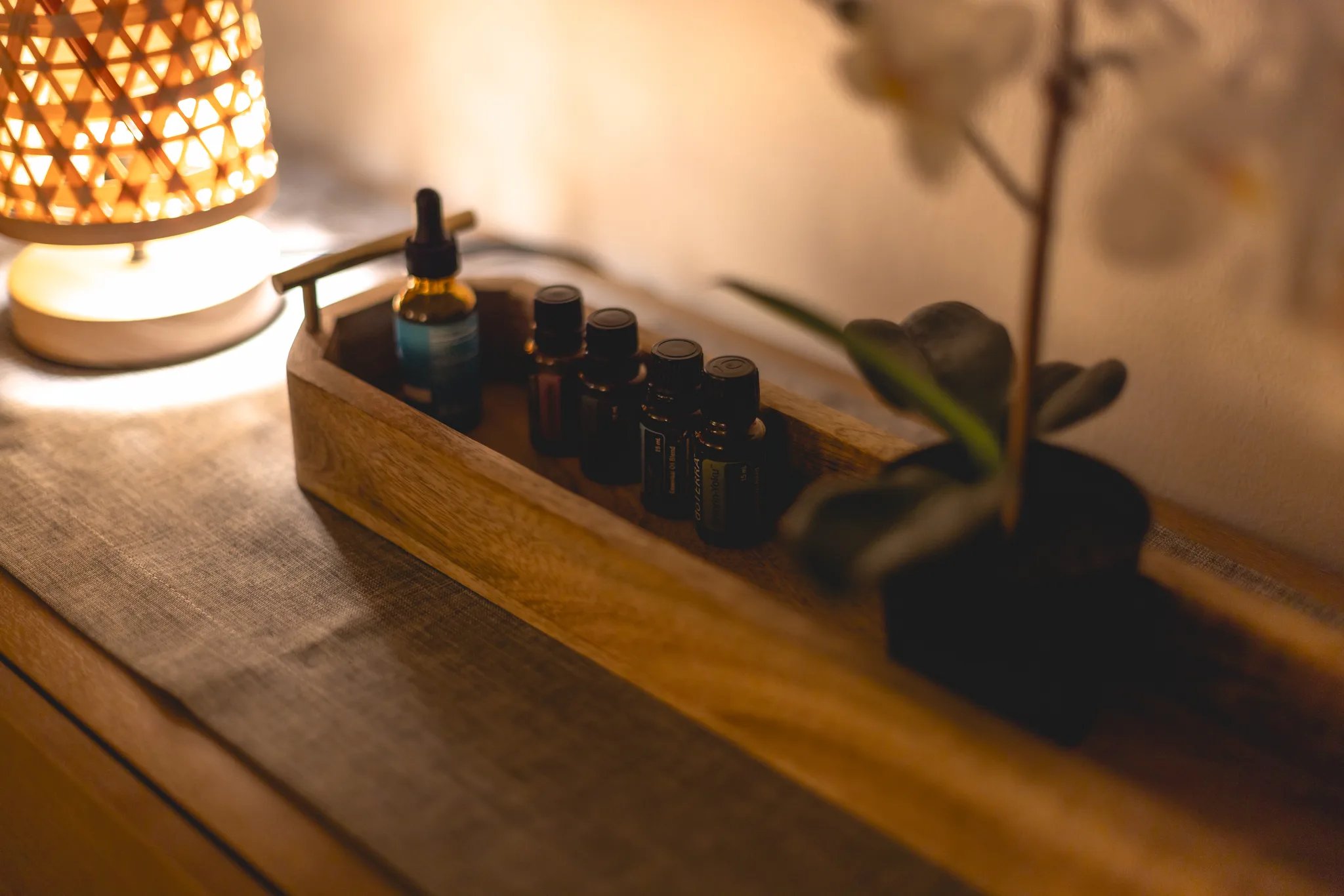 A tray of essential oils beside an orchid in the treatment room.