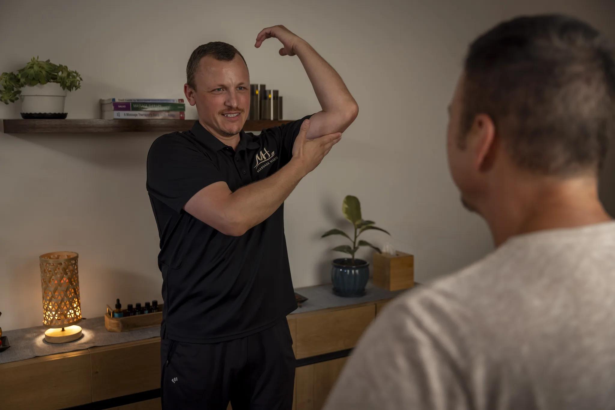 Dorian demonstrating a shoulder movement to a client during a session.